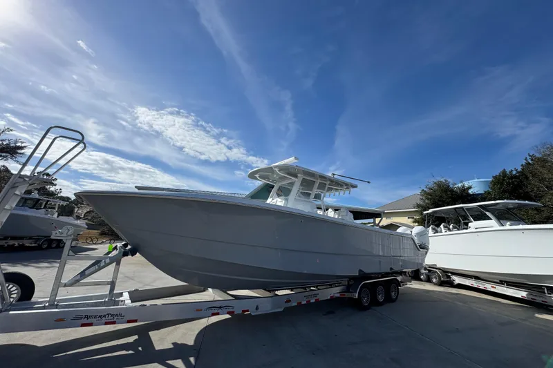 Slide: The Image of 2026 Invincible 36 Catamaran on trailer under clear blue sky. - 3