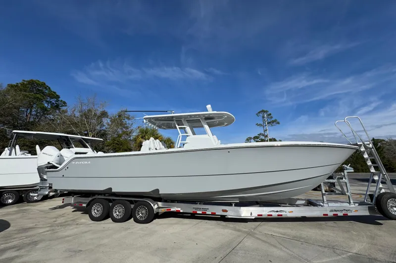 Slide: The Image of 2026 Invincible 36 Catamaran on trailer under clear blue sky. - 9