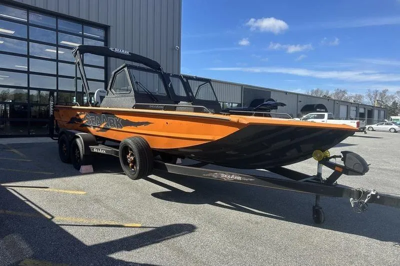 The Image of 2026 SeaArk ProCat 240 boat on trailer, parked outside a building under a clear sky. - 0