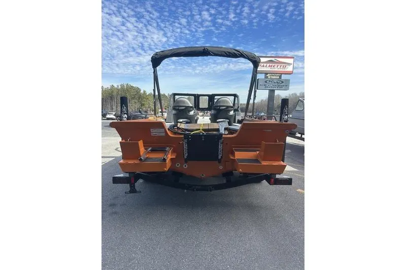 Slide: The Image of 2026 SeaArk ProCat 240 boat, rear view, orange color, parked outdoors under a blue sky. - 2