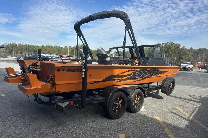 Slide: The Image of 2026 SeaArk ProCat 240 boat on trailer, vibrant orange design, parked outdoors. - 4