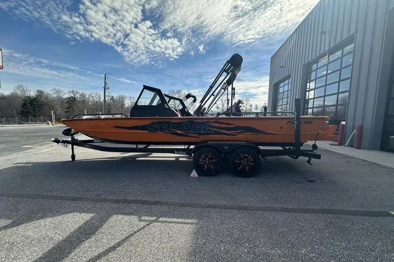Slide: The Image of 2026 SeaArk ProCat 240 boat on trailer, parked outdoors under a partly cloudy sky. - 5