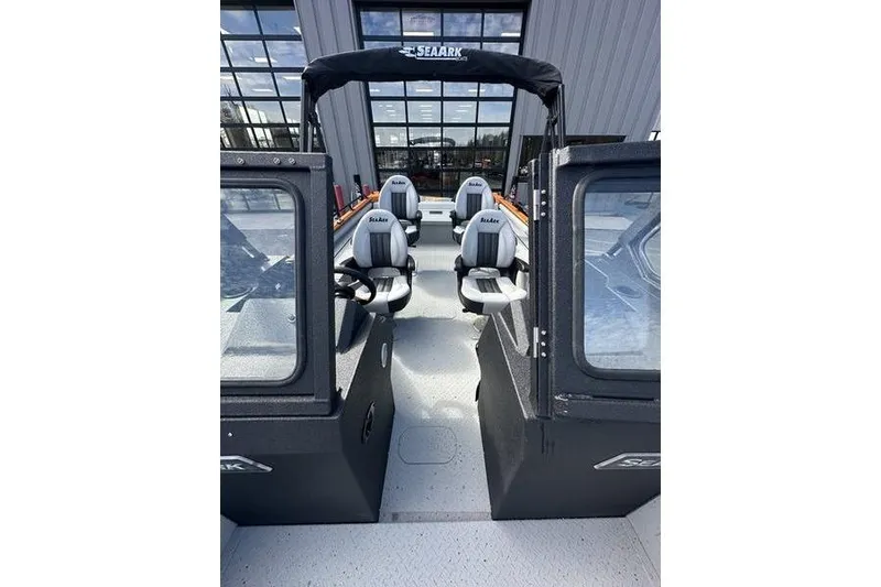 Slide: The Image of 2026 SeaArk ProCat 240 boat interior with seating and canopy, displayed in a showroom. - 9