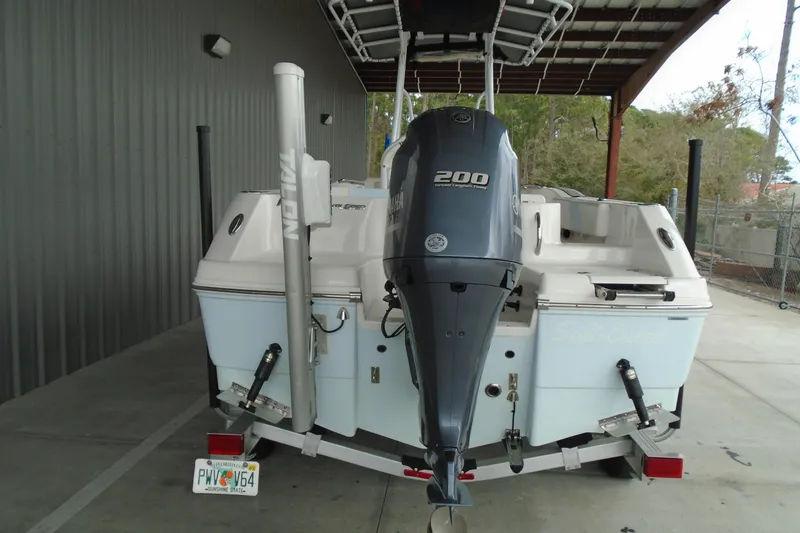 Slide: The Image of 2021 Robalo R202 Explorer boat with 200 HP engine, parked under a shelter. - 13