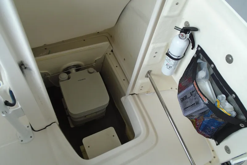 Slide: The Image of 2021 Robalo R202 Explorer boat interior with portable toilet and safety equipment. - 23