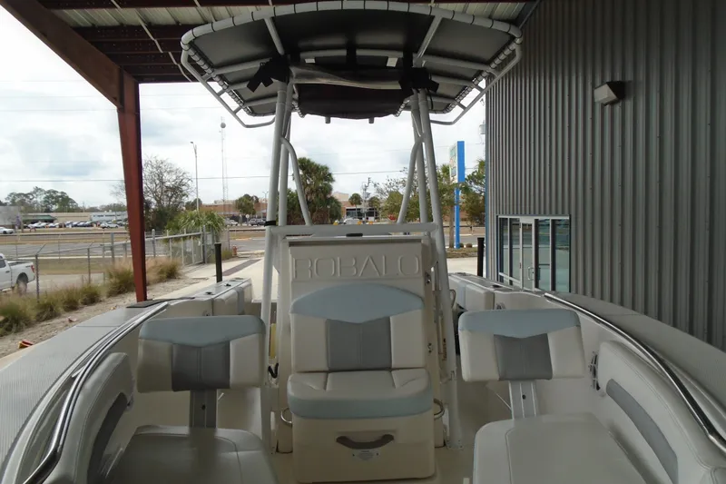 Slide: The Image of 2021 Robalo R202 Explorer boat interior with seating and helm, under a covered area. - 9