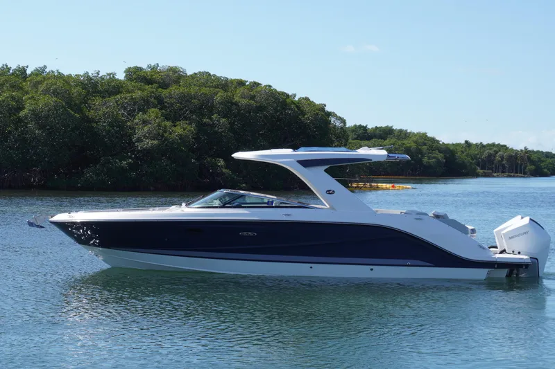 The Image of 2020 Sea Ray SLX 310 Outboard boat on calm water with lush green background. - 0
