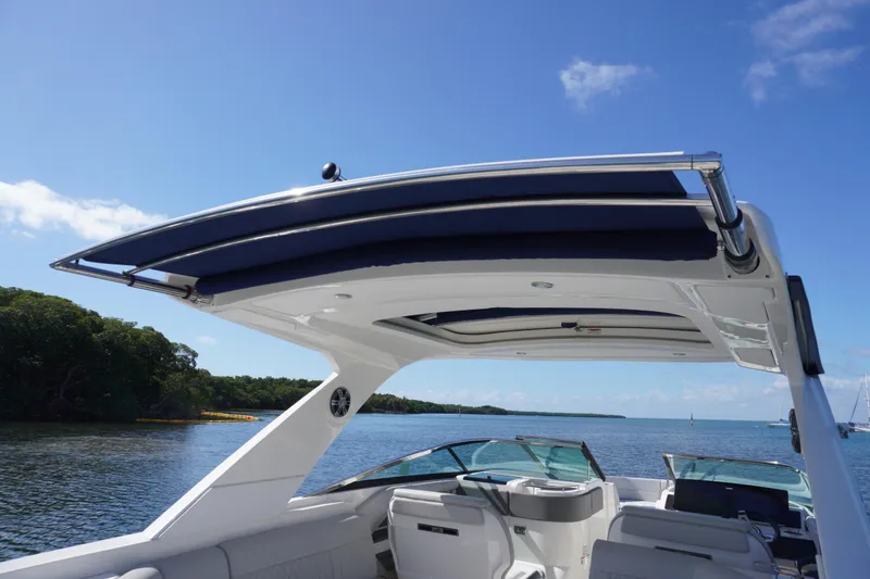 Slide: The Image of 2020 Sea Ray SLX 310 Outboard boat with sleek canopy on a sunny day. - 20