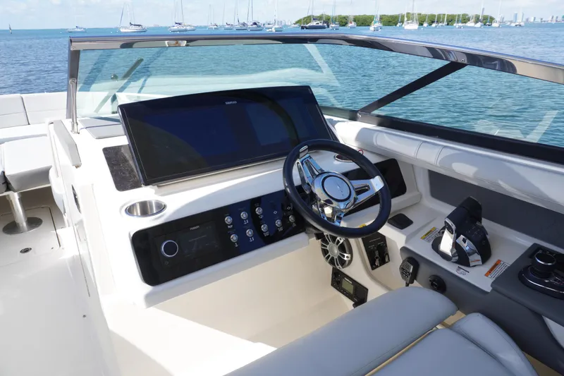 Slide: The Image of 2020 Sea Ray SLX 310 Outboard helm with modern controls and scenic ocean view. - 6