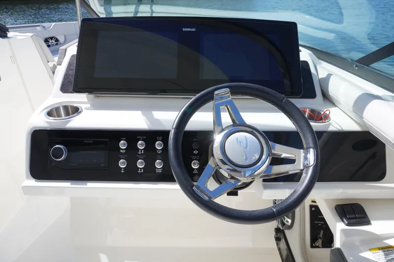 Slide: The Image of 2020 Sea Ray SLX 310 Outboard helm with steering wheel and control panel. - 7