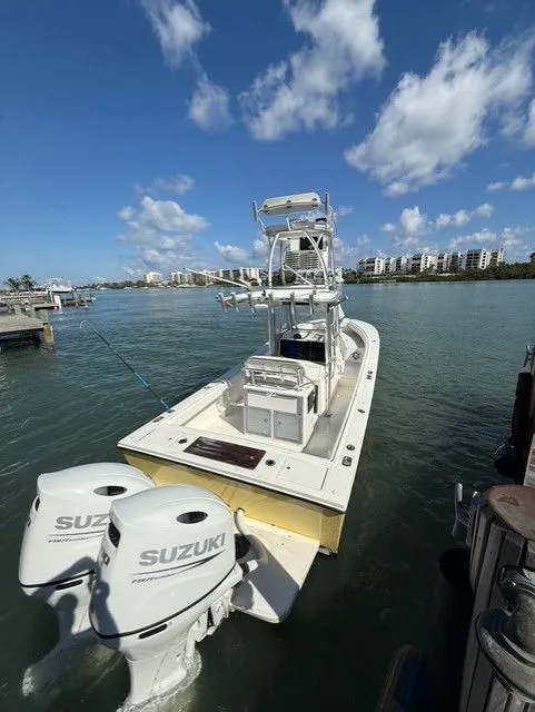 Slide: The Image of 2004 Regulator 26 Center Console boat with Suzuki engines at dock. - 2