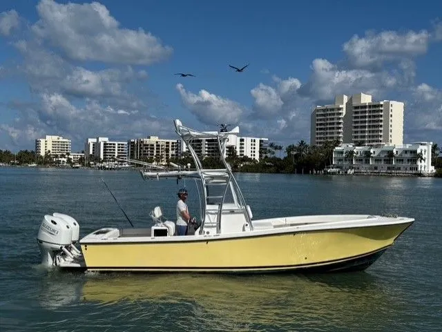 Slide: The Image of Yellow 2004 Regulator 26 Center Console boat on water near high-rise buildings. - 4