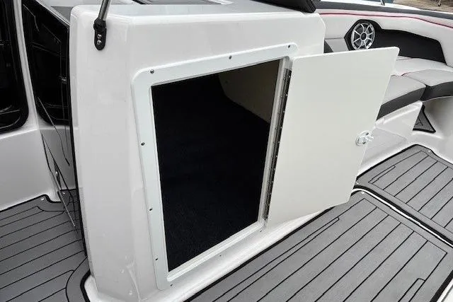 Slide: The Image of 2018 Yamaha Boats 212X storage compartment with open door, showcasing interior space. - 15