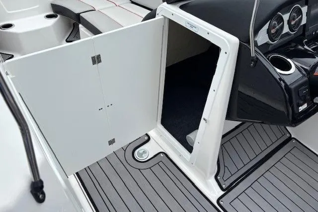 Slide: The Image of 2018 Yamaha Boats 212X interior storage compartment with open door, showcasing sleek design. - 18