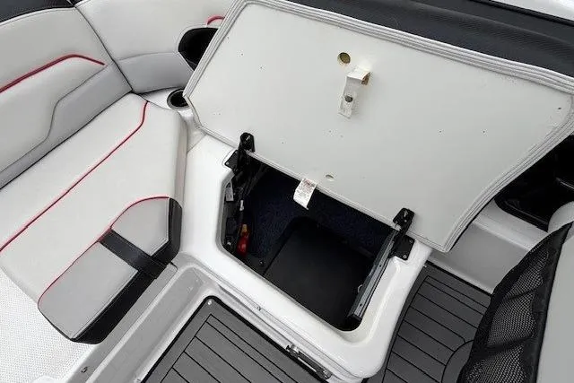 Slide: The Image of 2018 Yamaha Boats 212X interior storage compartment with white and black seating. - 30