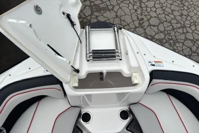 Slide: The Image of 2018 Yamaha Boats 212X bow area with open storage compartment and ladder. - 9