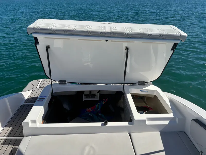 Slide: The Image of 2024 Sea Ray SPX 210 Outboard storage compartment open on water. - 17