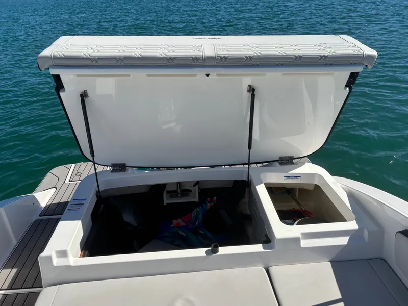 Slide: The Image of 2024 Sea Ray SPX 210 Outboard with open storage compartment on water. - 18