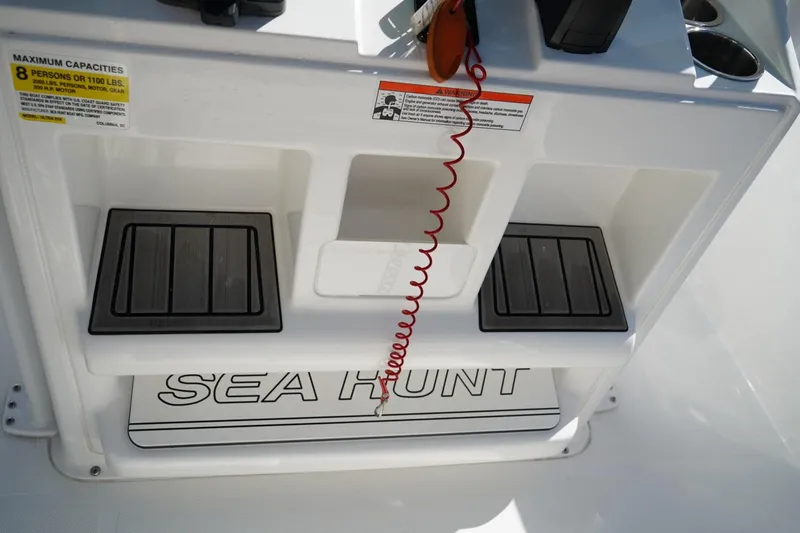 Slide: The Image of 2021 Sea Hunt Ultra 219 boat console with capacity label and footrests. - 33