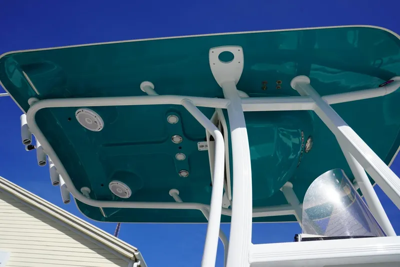 Slide: The Image of 2021 Sea Hunt Ultra 219 boat T-top with speakers against clear blue sky. - 4