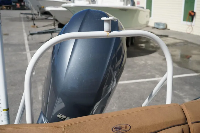 Slide: The Image of 2021 Sea Hunt Ultra 219 boat engine and seating detail in a marina. - 46