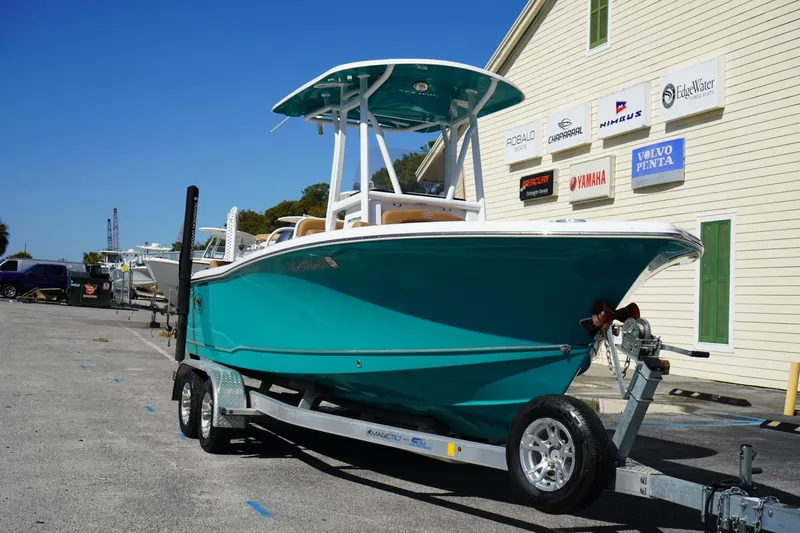 Slide: The Image of 2021 Sea Hunt Ultra 219 boat on trailer, parked near marine dealership. - 47