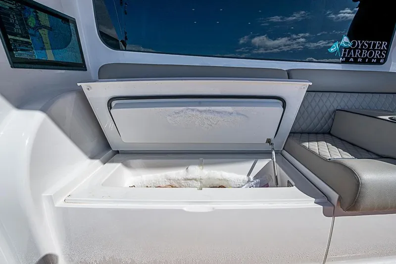 Slide: The Image of Open storage compartment on 2026 Viking 54 Convertible yacht, featuring cushioned seating and navigation display. - 11