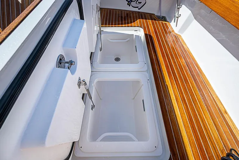 Slide: The Image of 2026 Viking 54 Convertible yacht with open storage compartments on polished wooden deck. - 14