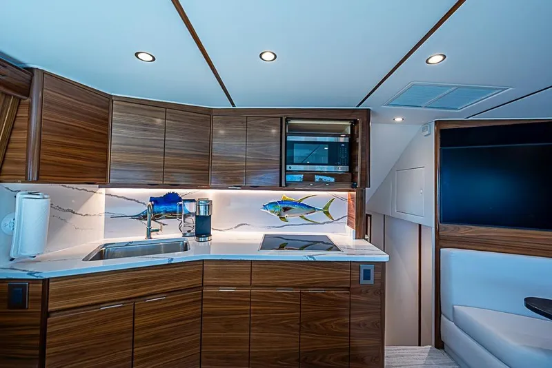 Slide: The Image of Luxurious kitchen interior of 2026 Viking 54 Convertible yacht with modern wood cabinetry. - 37