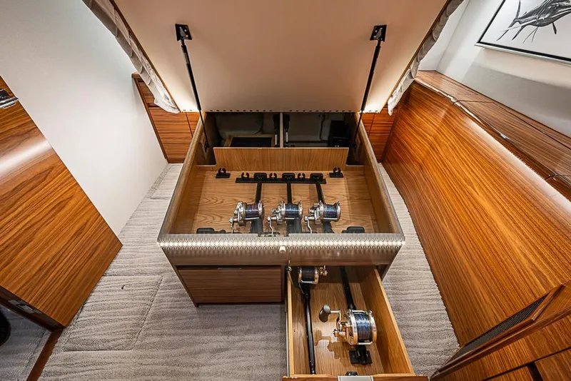 Slide: The Image of Luxurious interior of 2026 Viking 54 Convertible yacht with wood finish and fishing gear storage. - 42
