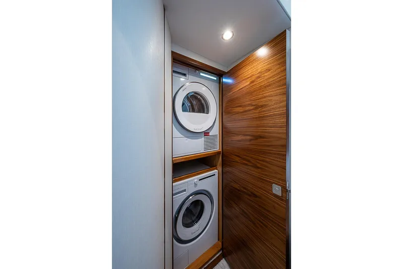 Slide: The Image of Laundry area with stacked washer and dryer in 2026 Viking 54 Convertible yacht. - 49