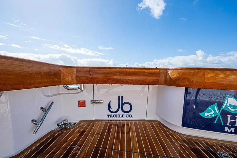 Slide: The Image of 2026 Viking 54 Convertible yacht deck with wooden finish and tackle company logo. - 7