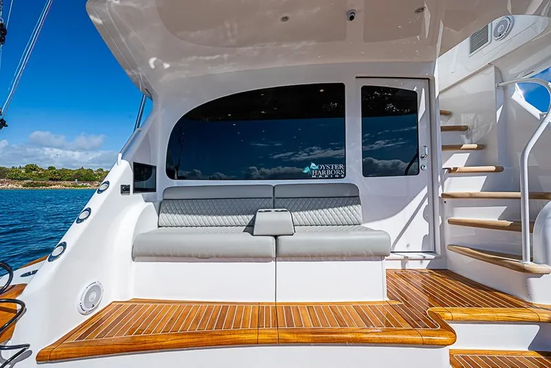 Slide: The Image of 2026 Viking 54 Convertible yacht with sleek seating and wooden deck, docked by serene waters. - 8