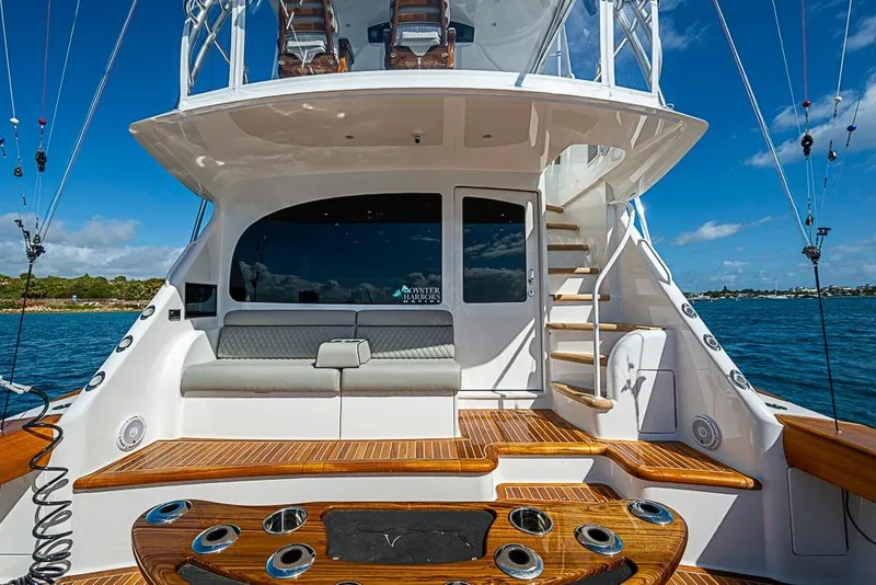 Slide: The Image of 2026 Viking 54 Convertible yacht with elegant deck and seating, docked on a sunny day. - 9