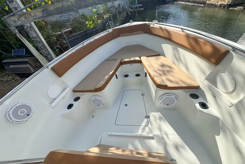 Slide: The Image of 2005 Sailfish 2660 CC boat interior with tan cushions and white speakers. - 10
