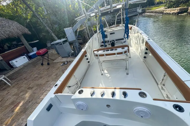 Slide: The Image of 2005 Sailfish 2660 CC boat docked by a scenic riverside patio. - 16