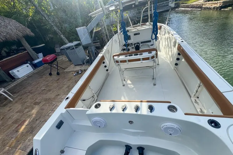 Slide: The Image of 2005 Sailfish 2660 CC boat docked by a serene waterfront. - 18