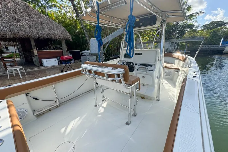 Slide: The Image of 2005 Sailfish 2660 CC boat with spacious deck and seating, docked near a tropical setting. - 21