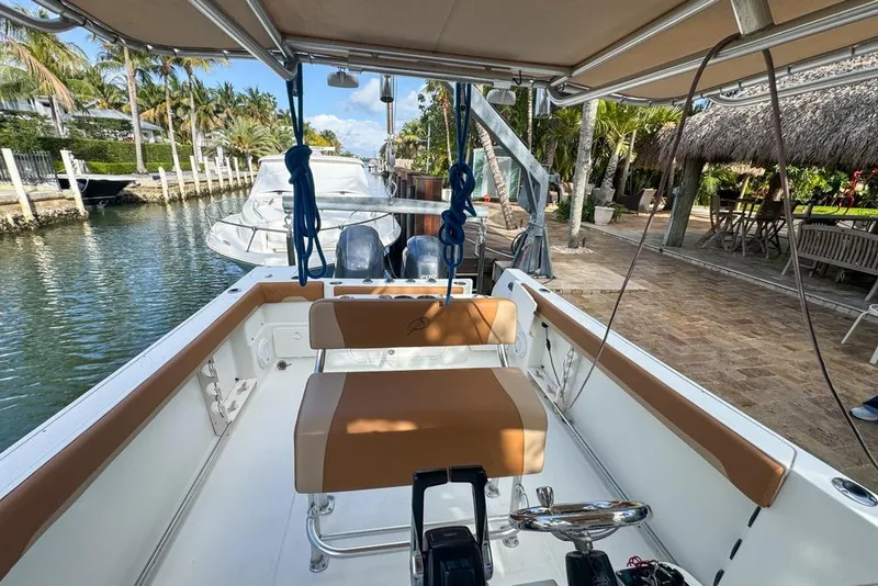 Slide: The Image of 2005 Sailfish 2660 CC boat docked by a tropical waterfront patio. - 28
