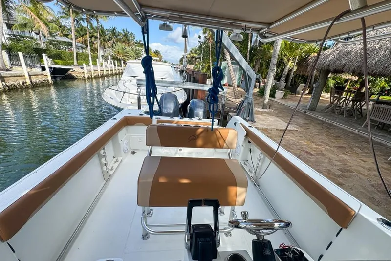 Slide: The Image of 2005 Sailfish 2660 CC boat interior, docked by a canal with palm trees. - 29