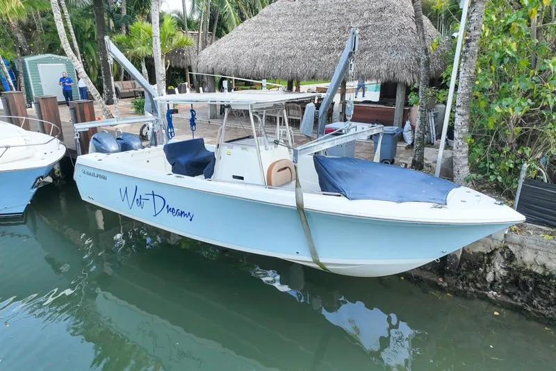 Slide: The Image of 2005 Sailfish 2660 CC boat docked with "Wet Dreams" name on side. - 3