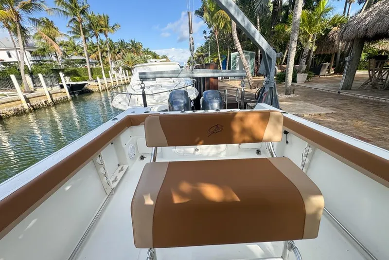 Slide: The Image of 2005 Sailfish 2660 CC boat docked by palm trees, featuring tan seating. - 30