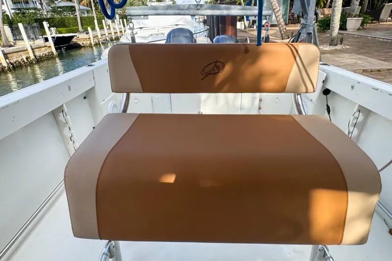 Slide: The Image of 2005 Sailfish 2660 CC boat seat with tan upholstery, dockside view. - 32