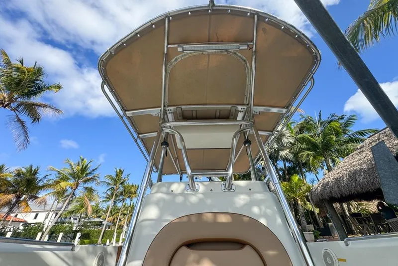 Slide: The Image of 2005 Sailfish 2660 CC boat with canopy, surrounded by palm trees and blue sky. - 34