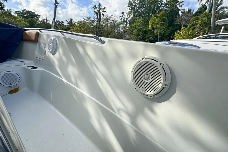 Slide: The Image of 2005 Sailfish 2660 CC boat interior with speakers and lush greenery background. - 42