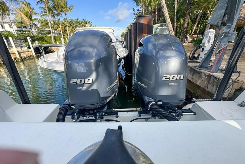Slide: The Image of Twin Yamaha 200 engines on a 2005 Sailfish 2660 CC boat docked by palm trees. - 44