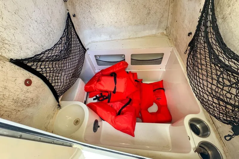 Slide: The Image of Interior of 2005 Sailfish 2660 CC boat with red life jackets and storage nets. - 48