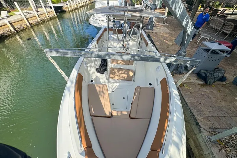 Slide: The Image of 2005 Sailfish 2660 CC boat docked in a canal, featuring tan seating and a center console. - 8
