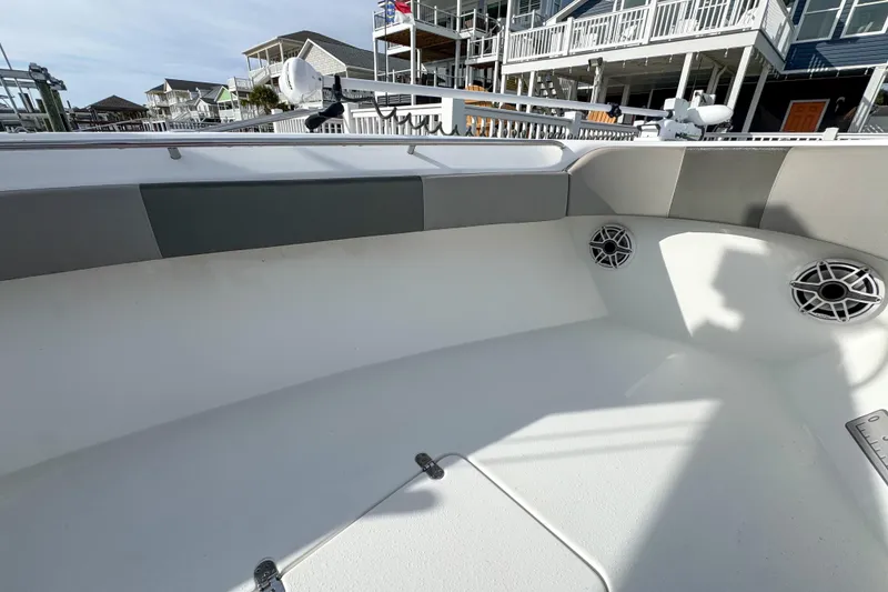 Slide: The Image of 2021 Cape Horn 31 T boat interior with speakers and seating, docked near waterfront homes. - 14