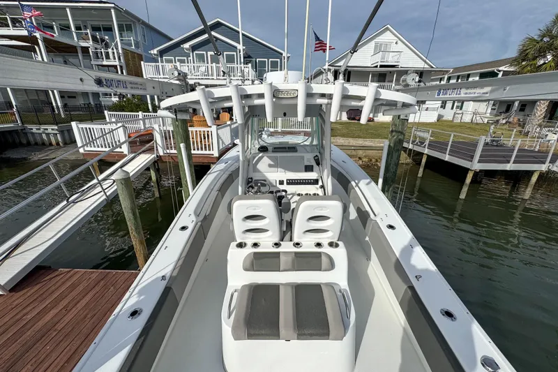 Slide: The Image of 2021 Cape Horn 31 T boat docked with American flag, residential background. - 9